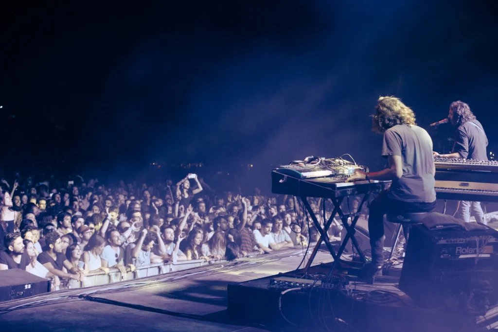 Konserttikuvaan tallentunut tunnelma lavalta kuvattuna, esiintymässä War on Drugs ja yleisöä.